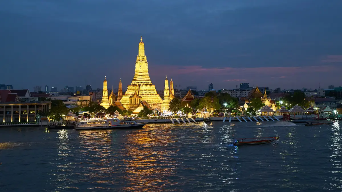 Wat Arun lit up at night across the river