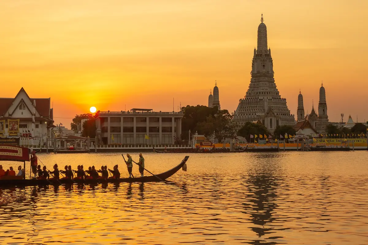 Wat Arun at sunset with a long boat on the river